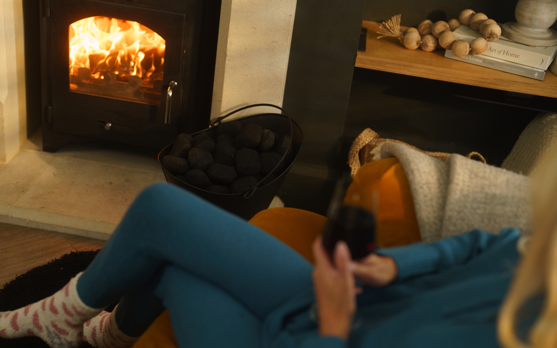 Woman sitting next to a multifuel stove